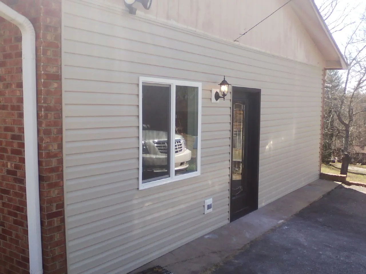 New vinyl siding and entry door on a room addition in Holly Ridge