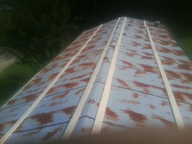 Rusted metal roof panels with new wood purlins before replacement — Storm Damage Roof Repair in Holly Ridge by Roofing Brothers