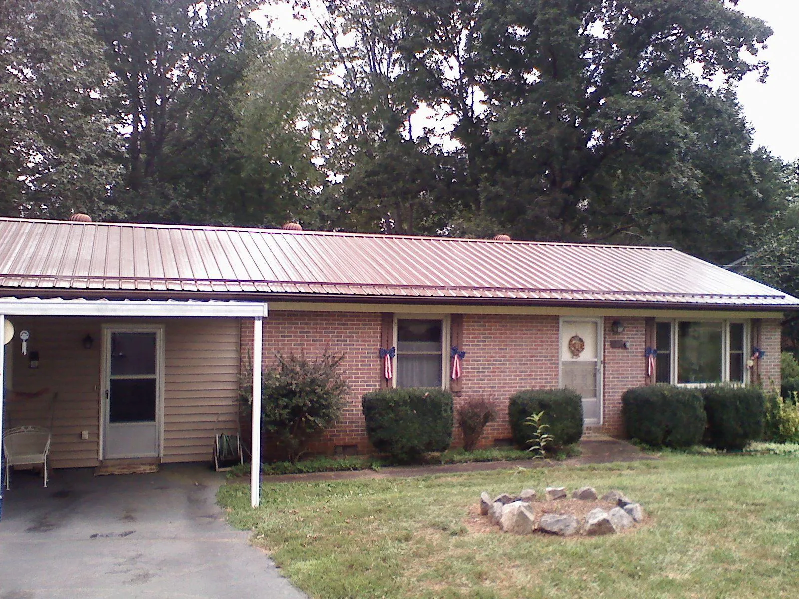 Bronze metal roof and carport on a brick ranch home — Roof Repair work by our crew in Holly Ridge