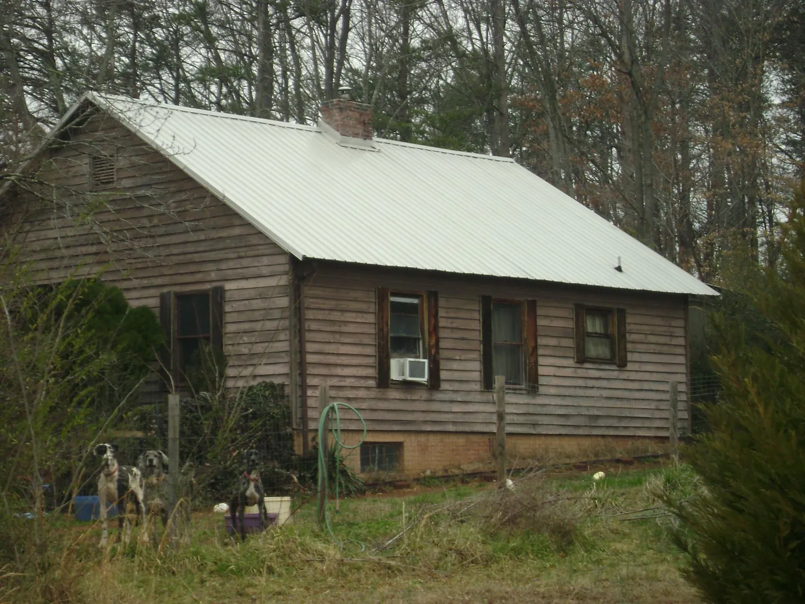 White metal roof on an old wood sided farmhouse, from a Metal Roof Installation job in Holly Ridge